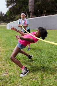 Kids enjoying a fun limbo game at a summer camp in the park.